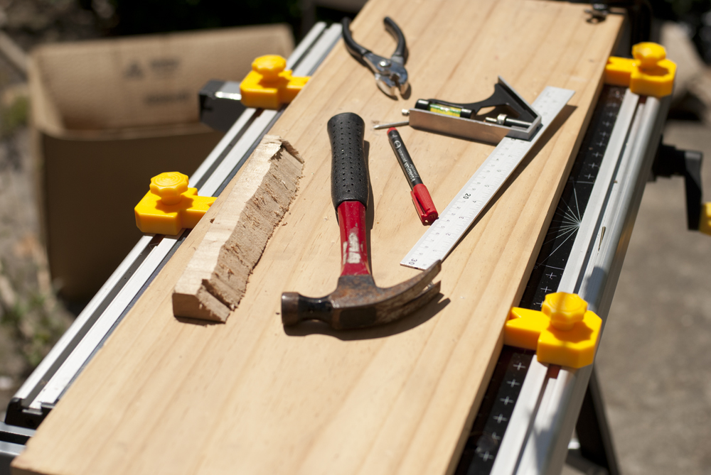 A photo of several carpentry tools lying on a board; Published as part of 