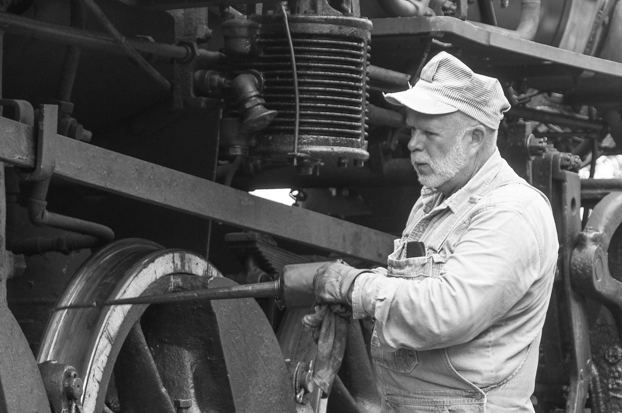 An old railroad engineer tuning up a locomotive, published as part of "Complete Guide to Launching a WordPress Site: Part 2 (Maintenance)"